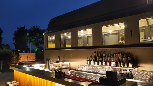 Il bancone bar esterno acceso all'ora blu, sotto i finestrini illuminati della carrozza