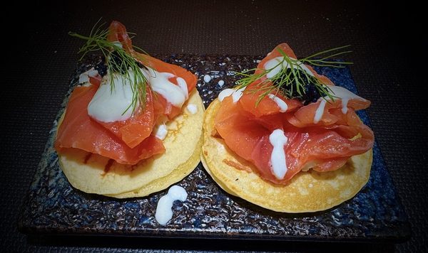 Blinis con burro affumicato e uova di trota, serviti come entrée